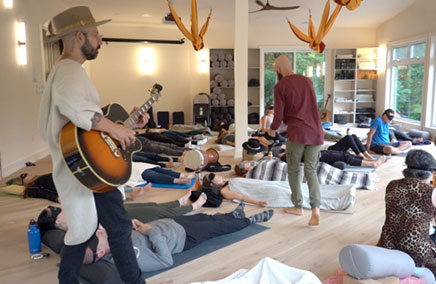 A breathwork coach guiding clients during a session with music integration.